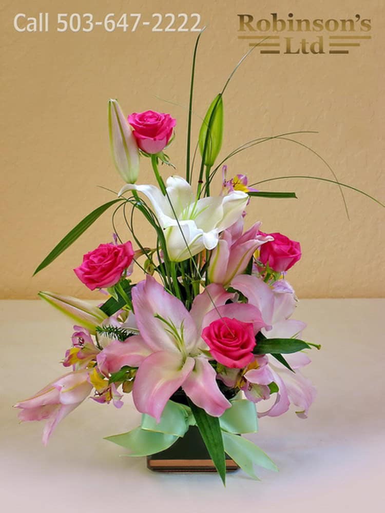 Pink lilies and roses arranged by Robinsons LTD